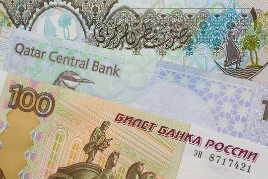 A Russian ruble note on a background of money from Qatar
