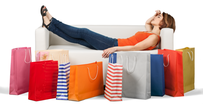 Woman lying on the sofa behind a row of bags tired after shopping
