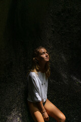 Naklejka premium Woman tourist at a waterfall in the tropical jungle, Bali.