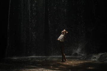 Woman tourist at a waterfall in the tropical jungle, Bali.