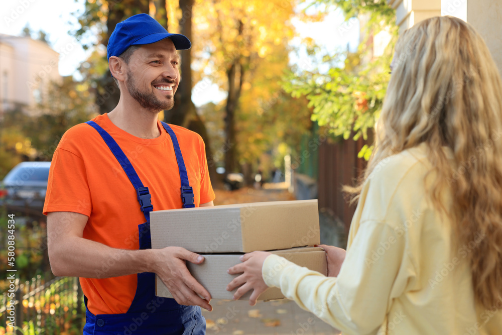 Canvas Prints Woman receiving parcels from courier in uniform outdoors