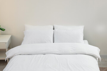 Fototapeta na wymiar White soft pillows on cozy bed in room