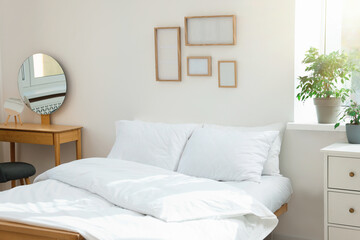 Bed with soft white pillows in cozy room interior