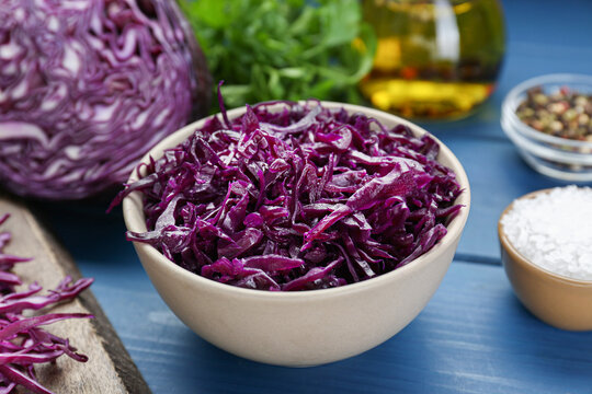 Tasty red cabbage sauerkraut and different ingredients on light blue wooden table