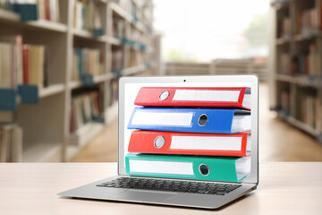 Store and organize information. Hardcover office folders getting out of modern laptop in archive...