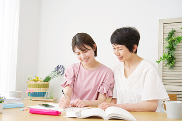 家で母親と勉強する娘
