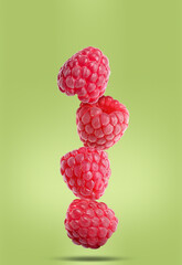 Fresh ripe raspberries falling on light green background