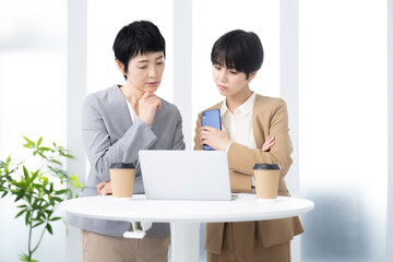 ビジネスマン　女性チーム　パソコンを考えて見つめる