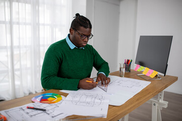 Black Male Designer Working Drawing Sitting Near Computer In Office
