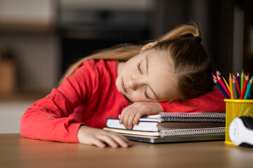Portrait Of Little Female Child Sleeping At Desk, Tired After Doing Homework