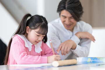 Obraz na płótnie Canvas 勉強をする子供と教える父