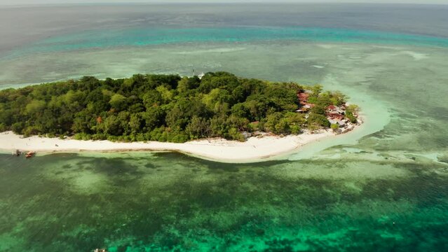 Tropical island and sandy beach surrounded by atoll and coral reef with turquoise water, aerial drone. Tropical island and coral reef. Summer and travel vacation concept, Camiguin, Philippines