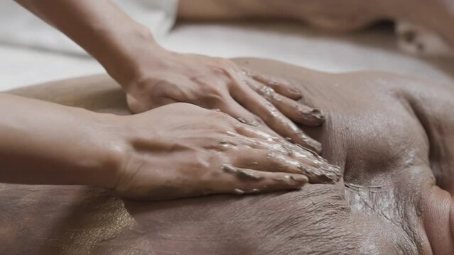 Male receiving Back Body Scrub Mud Therapy Mud Wrap Massage Luxury Spa Therapy Revitalizing Skin Treatment, Wellness Natural Mud Body Scrub and Warp