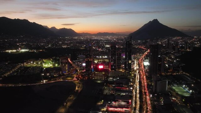 Aerial view of illuminated hi-rise in San Pedro Garza Garcia, Monterrey, dusk in Mexico - tracking, drone shot
