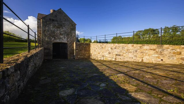 Timelapse of a historical lime kiln building during the day with passing clouds in rural landscape of county Leitrim in Ireland.