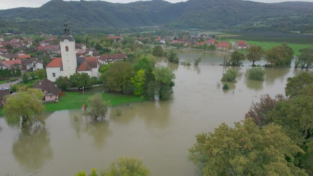 AERIAL: Lovely village in the countryside is surrounded by muddy flood water. River floods came dangerously close to the residential buildings in countryside after abundant rainfall in autumn season.