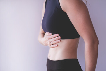 Fototapeta premium Woman suffering from stomach abdominal ache and holding hand on the belly, isolated on white background, studio shot