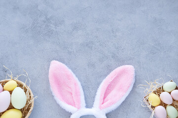 Colorful Easter eggs with rabbit ears on yellow background.
