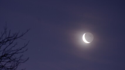 Waning crescent moon set against spooky night sky