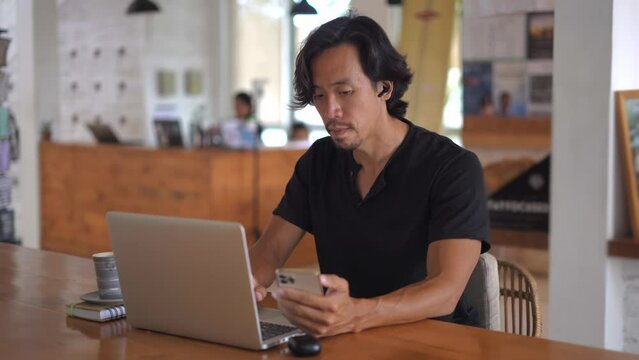Asian freelancer online sit work job cafe. Busy people talk video link conference. Boss person use cell mobile phone meeting call covid-19. Guy user iphone chat Asia. Man start up airpods headphones.