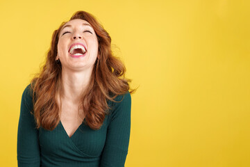 Happy redheaded woman laughing and looking up