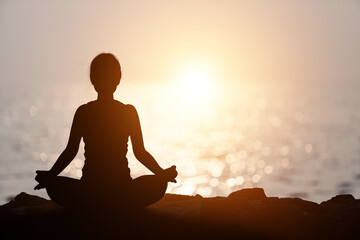 Silhouette Asia woman with Tree Pose yoga on the mountain at pastel sunset background