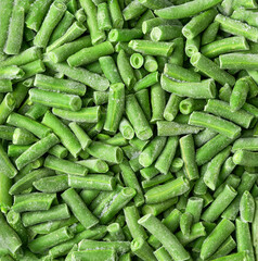 Frozen cut green beans close up top view background.