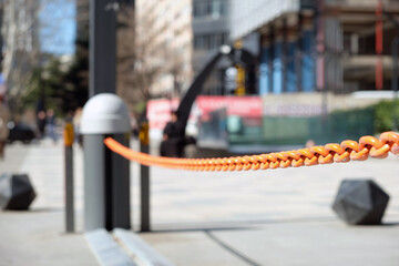 Close-up of an automatic barrier with an orange chain at the entrance to an underground parking in the city.