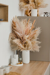 Vase with a bouquet of pampas grass.
Beige still life. Bouquet of dried flowers. Eternal bouquet.
Interior decor. Boho style. Beige and white.