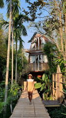 wooden cottage surrounded by palm trees and a vegetable garden in the countryside. cabin in...