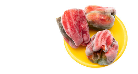 Frozen bell pepper in yellow plate isolated on white background.