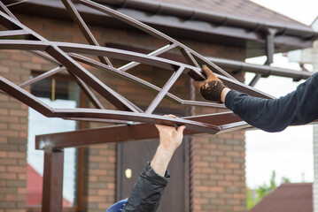 The worker installs the metal on the canopy.