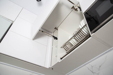 Modern lifting mechanism of the door of the facade of the kitchen. Storage of dishes in a separate section, kitchen system
