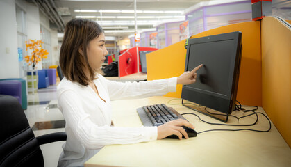 Beautiful asian office girl inding work bug on computer in corporate office.