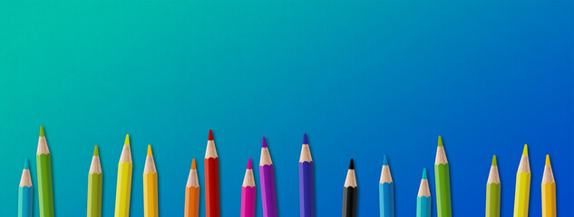 Colored pencil group isolated on blue. Panoramic banner background