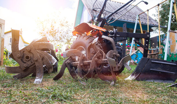 Agricultural walk-behind tractor with a set of attachments, hiller, milling cutters and lugs. Two-wheel tractor, industry