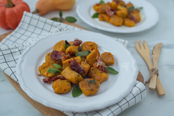 Healthy home made Pumpkin gnocchi with cheese and fresh herbs on a table