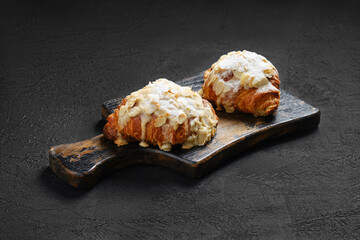 Crispy croissant with caramel on wooden serving board