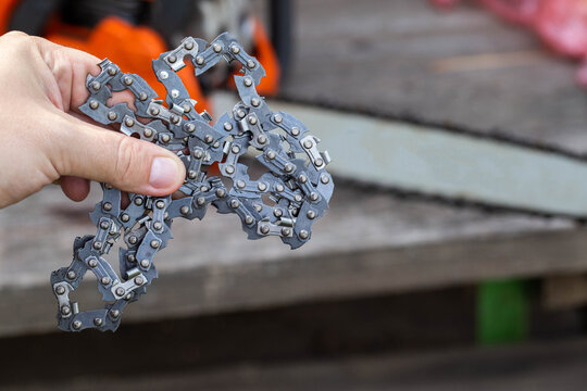 New chain for chainsaw. Setting up and replacing the chain on the chainsaw from the old to the new. Chain sharpening. Industry