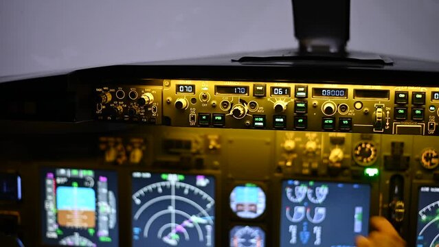 A man is studying to be a pilot in a flight simulator. Close-up of male hands on the control panel of an aircraft.