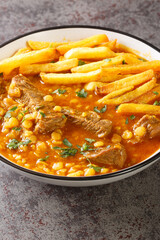 Khoresh Gheymeh is a Beef and Split Pea Stew with saffron potatoes closeup on a plate on the table. Vertical
