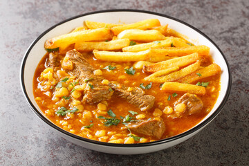 Khoresh Gheymeh yellow split peas, saffron, tomato paste, diced meat, and sun-dried lime are the main ingredients of this delicious stew closeup on a plate on the table. Horizontal