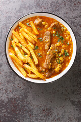Khoresh Gheymeh is a Beef and Split Pea Stew with saffron potatoes closeup on a plate on the table. Vertical top view from above