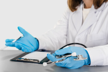 Professional female doctor writing receipt with medicine on studio gray background