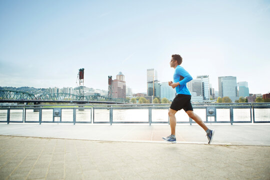 Man jogging on promenade against clear sky