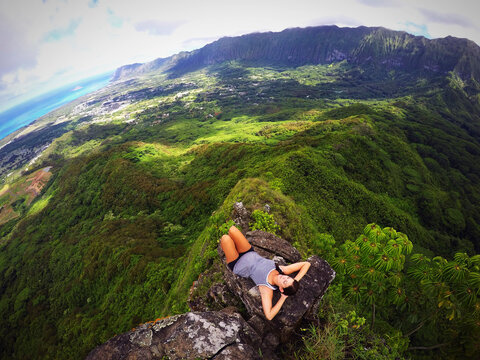 High angle view of woman relaxing on mountain cliff