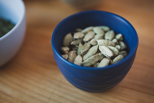 Close-up of cardamoms in bowl on wooden table