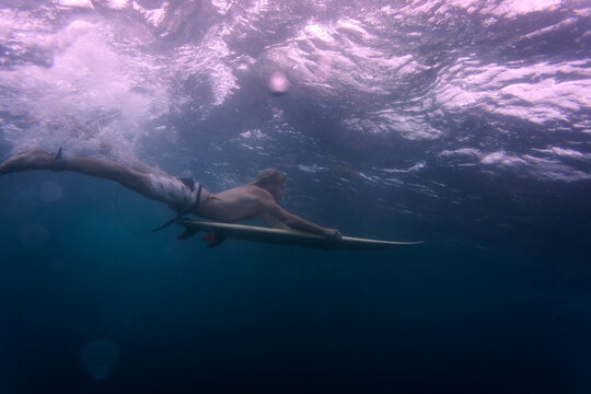 Side view of man with surfboard undersea