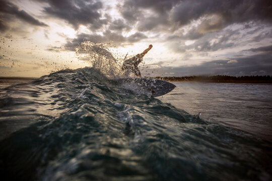 Man performing stunt while surfboarding in sea