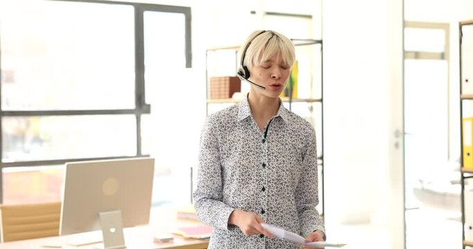 Businesswoman in headphones with microphone talking remotely in office 4k movie